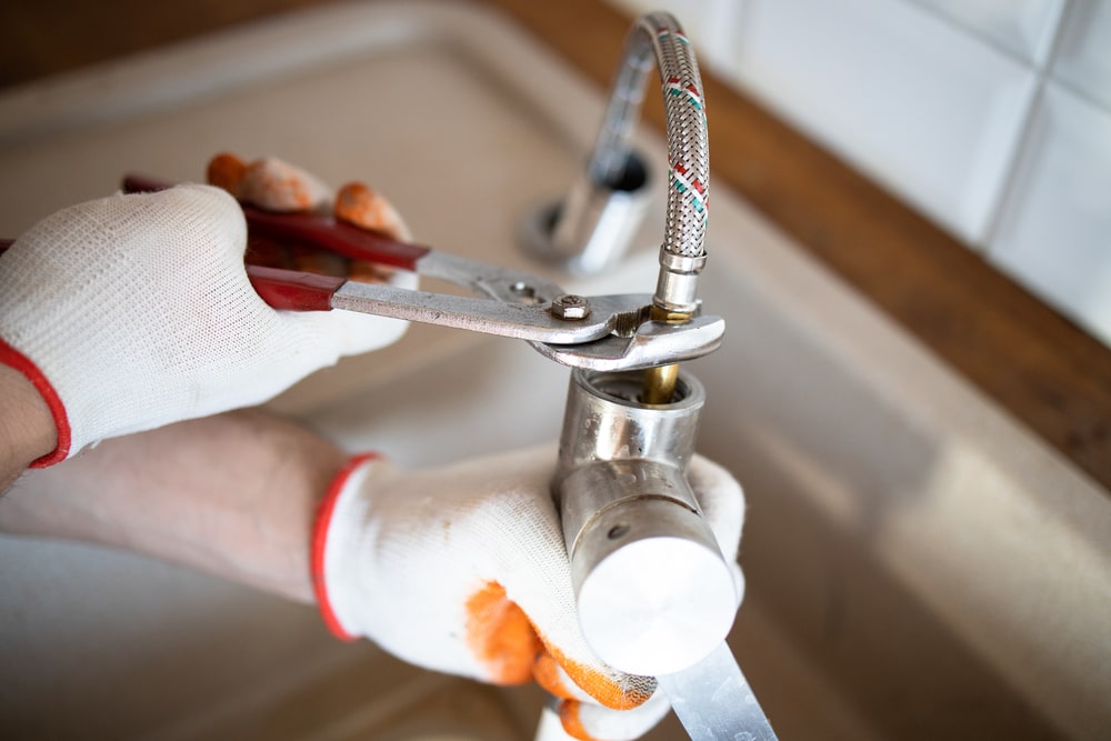 plumber repairing a pipe with wrench