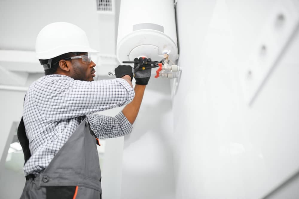 Young Plumber Installing Water Heater